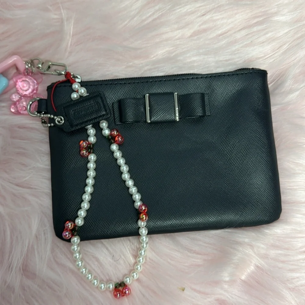 Elegant Black Women's Coach wristlet with bow coquette